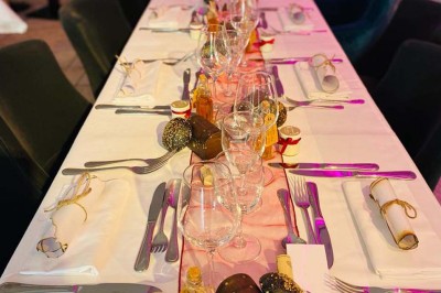 Bâtiment d'hôtel en pierre avec trois étoiles, entouré de végétation et d'une façade partiellement recouverte de lierre.