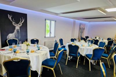 Bâtiment d'hôtel en pierre avec trois étoiles, entouré de végétation et d'une façade partiellement recouverte de lierre.