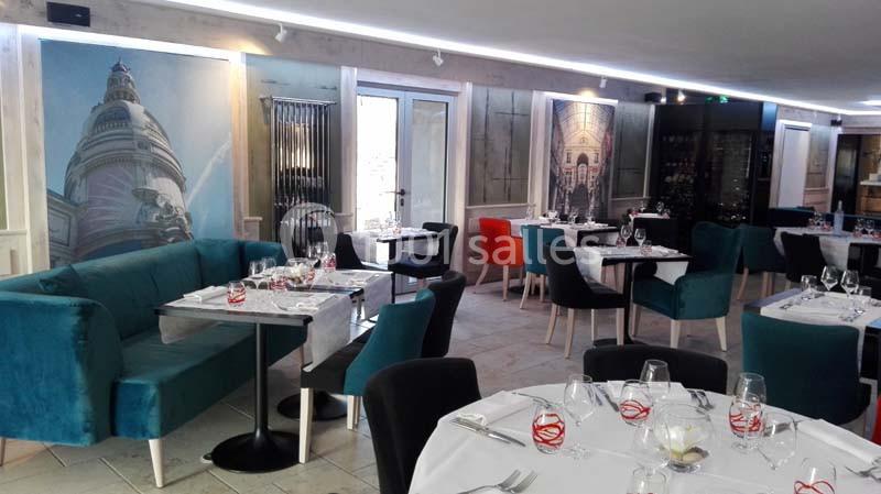 Salle de restaurant moderne avec tables dressées, chaises colorées et décorations murales représentant des monuments.