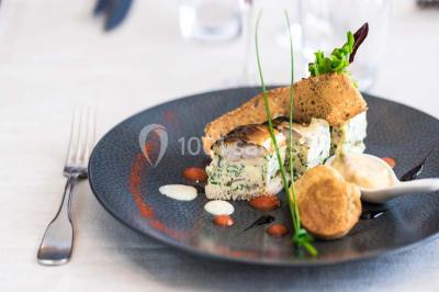 Piscine extérieure entourée de chaises longues et parasols, avec des bâtiments en arrière-plan sous un ciel dégagé.