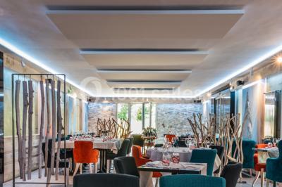 Piscine extérieure entourée de chaises longues et parasols, avec des bâtiments en arrière-plan sous un ciel dégagé.