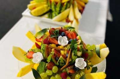 Piscine extérieure entourée de chaises longues et parasols, avec des bâtiments en arrière-plan sous un ciel dégagé.