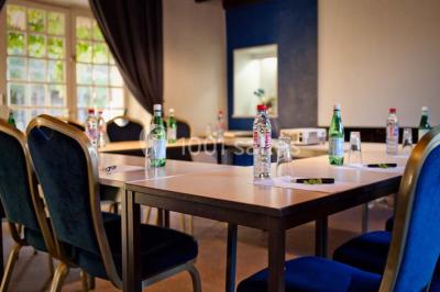 Piscine extérieure entourée de chaises longues et parasols, avec des bâtiments en arrière-plan sous un ciel dégagé.