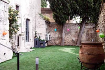 Salon lumineux avec fauteuils en cuir, table basse en bois, paniers en osier, escaliers et décorations florales.