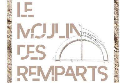 Salon lumineux avec fauteuils en cuir, table basse en bois, paniers en osier, escaliers et décorations florales.