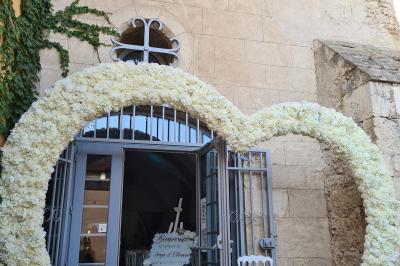 Salon lumineux avec fauteuils en cuir, table basse en bois, paniers en osier, escaliers et décorations florales.
