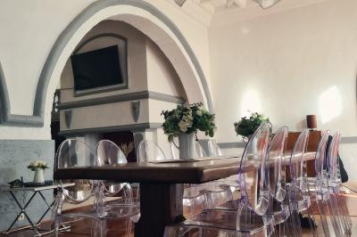 Salon lumineux avec fauteuils en cuir, table basse en bois, paniers en osier, escaliers et décorations florales.