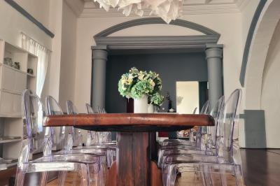 Salon lumineux avec fauteuils en cuir, table basse en bois, paniers en osier, escaliers et décorations florales.
