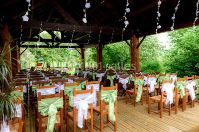 Chambre lumineuse avec deux lits simples, sol en carrelage, plafond en bois, et vue sur un jardin depuis une porte ouverte.