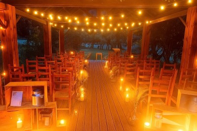 Façade d'une maison à colombages avec jardinières fleuries et un jardin verdoyant au premier plan.