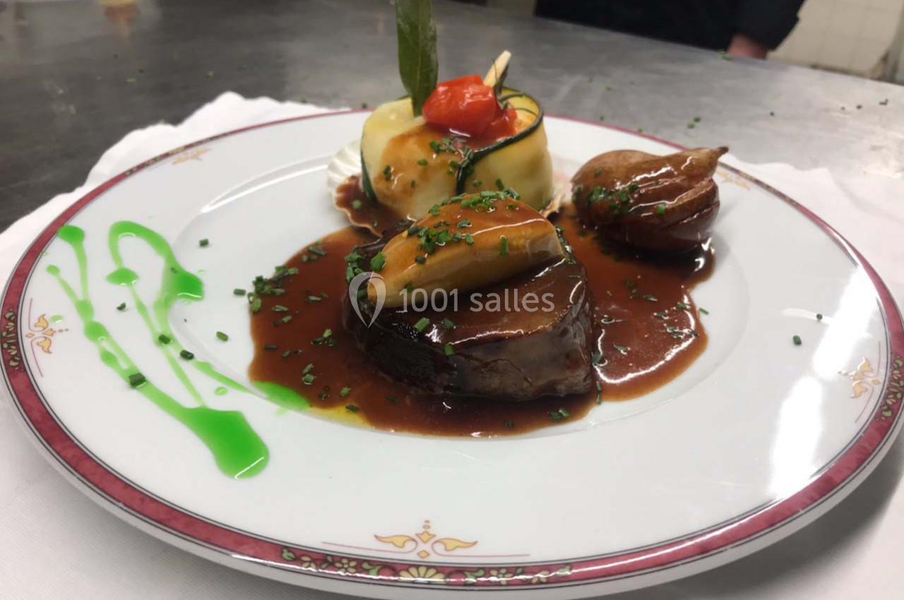 Assiette gastronomique avec filet de viande, sauce brune, purée, légumes et décoration soignée.