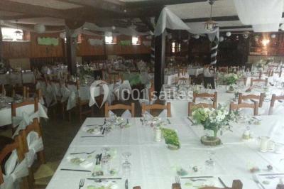 Grandes bûches pâtissières décorées de glaçage blanc, présentées sur une table ornée de guirlandes lumineuses et de…