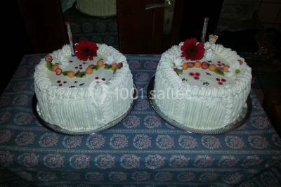 Grandes bûches pâtissières décorées de glaçage blanc, présentées sur une table ornée de guirlandes lumineuses et de…