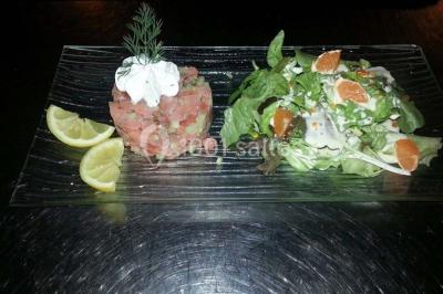 Grandes bûches pâtissières décorées de glaçage blanc, présentées sur une table ornée de guirlandes lumineuses et de…