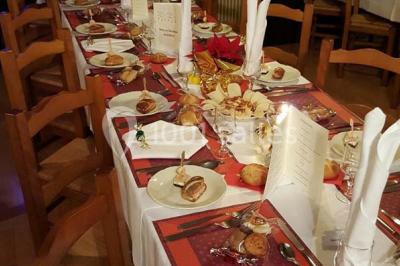 Grandes bûches pâtissières décorées de glaçage blanc, présentées sur une table ornée de guirlandes lumineuses et de…
