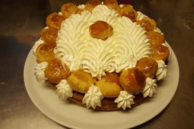 Grandes bûches pâtissières décorées de glaçage blanc, présentées sur une table ornée de guirlandes lumineuses et de…