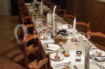 Grandes bûches pâtissières décorées de glaçage blanc, présentées sur une table ornée de guirlandes lumineuses et de…