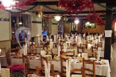 Grandes bûches pâtissières décorées de glaçage blanc, présentées sur une table ornée de guirlandes lumineuses et de…