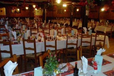 Grandes bûches pâtissières décorées de glaçage blanc, présentées sur une table ornée de guirlandes lumineuses et de…