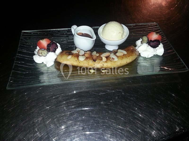 Banane flambée garnie d'amandes, accompagnée de glace vanille, fruits rouges, chantilly et sauce chocolat.