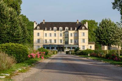 Chambre lumineuse avec un lit double, une fenêtre ouverte sur l'extérieur et un tableau accroché au mur.