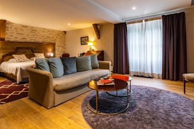 Chambre lumineuse avec un lit double, une fenêtre ouverte sur l'extérieur et un tableau accroché au mur.