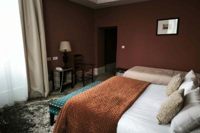 Chambre lumineuse avec un lit double, une fenêtre ouverte sur l'extérieur et un tableau accroché au mur.