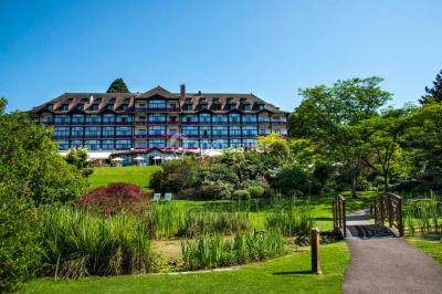 Salle lumineuse avec une grande table dressée, plafond végétalisé, canapés colorés et équipements de détente.