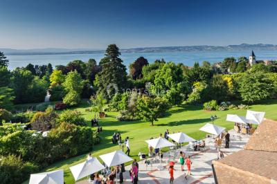 Salle lumineuse avec une grande table dressée, plafond végétalisé, canapés colorés et équipements de détente.