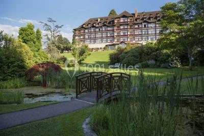 Salle lumineuse avec une grande table dressée, plafond végétalisé, canapés colorés et équipements de détente.