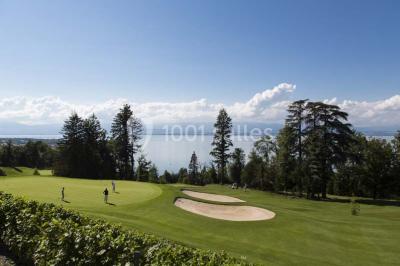 Salle lumineuse avec une grande table dressée, plafond végétalisé, canapés colorés et équipements de détente.