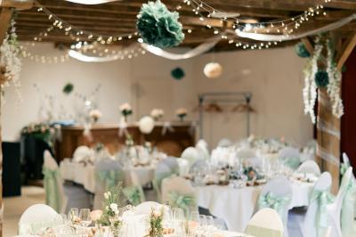 Chambre lumineuse avec lit double, rideaux transparents, plafond en poutres apparentes et vue sur une terrasse ensoleillée.