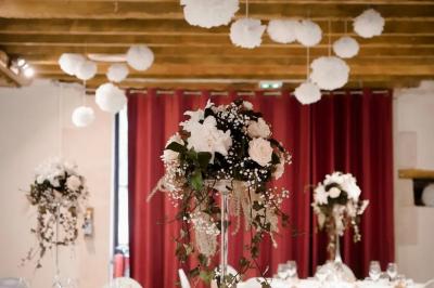 Chambre lumineuse avec lit double, rideaux transparents, plafond en poutres apparentes et vue sur une terrasse ensoleillée.