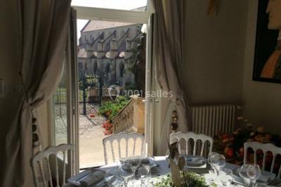 Voûtes en pierre éclairées par des lumières murales, avec des fenêtres laissant entrer la lumière naturelle.