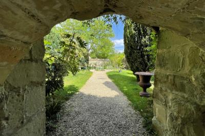 Voûtes en pierre éclairées par des lumières murales, avec des fenêtres laissant entrer la lumière naturelle.