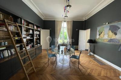 Voûtes en pierre éclairées par des lumières murales, avec des fenêtres laissant entrer la lumière naturelle.