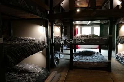 Aménagement de jardin avec un parterre circulaire entouré de pierres, contenant des plantes, sur fond de verdure et collines.