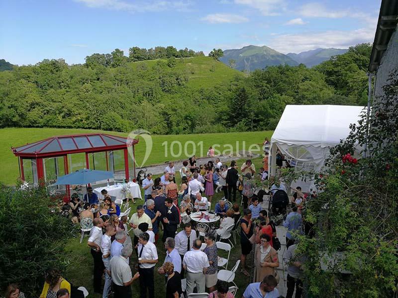 Groupe de personnes réunies en extérieur lors d'un événement, avec des collines verdoyantes en arrière-plan.