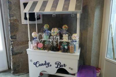 Aménagement de jardin avec un parterre circulaire entouré de pierres, contenant des plantes, sur fond de verdure et collines.