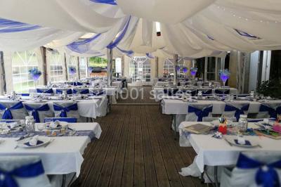 Aménagement de jardin avec un parterre circulaire entouré de pierres, contenant des plantes, sur fond de verdure et collines.