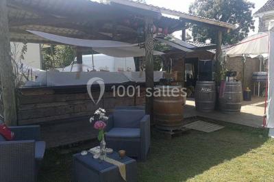 Aménagement de jardin avec un parterre circulaire entouré de pierres, contenant des plantes, sur fond de verdure et collines.