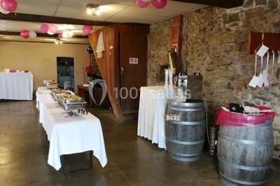 Aménagement de jardin avec un parterre circulaire entouré de pierres, contenant des plantes, sur fond de verdure et collines.