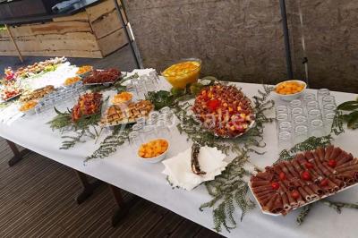 Aménagement de jardin avec un parterre circulaire entouré de pierres, contenant des plantes, sur fond de verdure et collines.