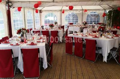 Aménagement de jardin avec un parterre circulaire entouré de pierres, contenant des plantes, sur fond de verdure et collines.