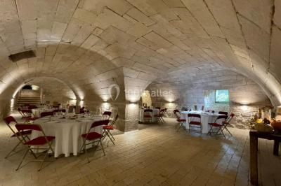 Façade d'un bâtiment en pierre de style classique avec tourelle, entouré d'une grille en fer forgé et d'un jardin.