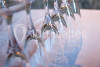Terrasse en pierre spacieuse devant un bâtiment ancien en pierre sous un ciel bleu dégagé.