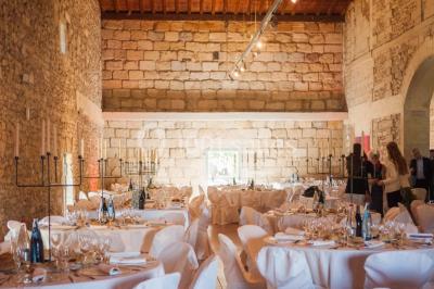 Terrasse en pierre spacieuse devant un bâtiment ancien en pierre sous un ciel bleu dégagé.