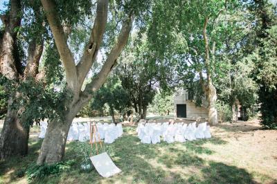 Terrasse en pierre spacieuse devant un bâtiment ancien en pierre sous un ciel bleu dégagé.
