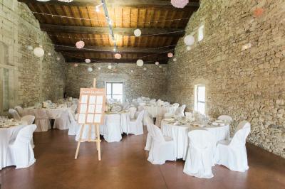Terrasse en pierre spacieuse devant un bâtiment ancien en pierre sous un ciel bleu dégagé.
