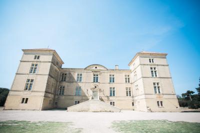 Terrasse en pierre spacieuse devant un bâtiment ancien en pierre sous un ciel bleu dégagé.